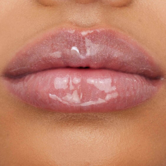 Close-up of fair-toned lips adorned with YSL LOVESHINE Plumping Gloss in Shade 1, highlighting its radiant, plumping effect.