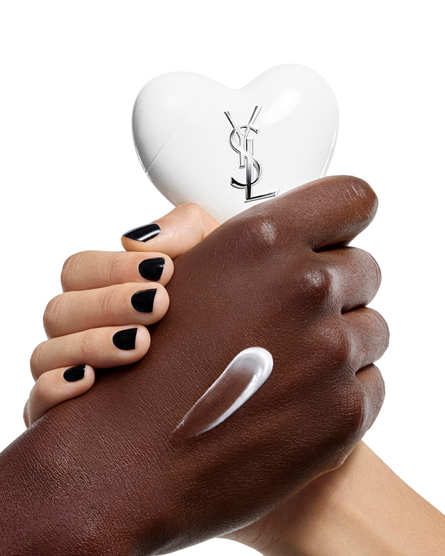 Dark and light-toned hands holding CARE CRUSH Hand & Body serum-in-cream, with a white cream swatch.